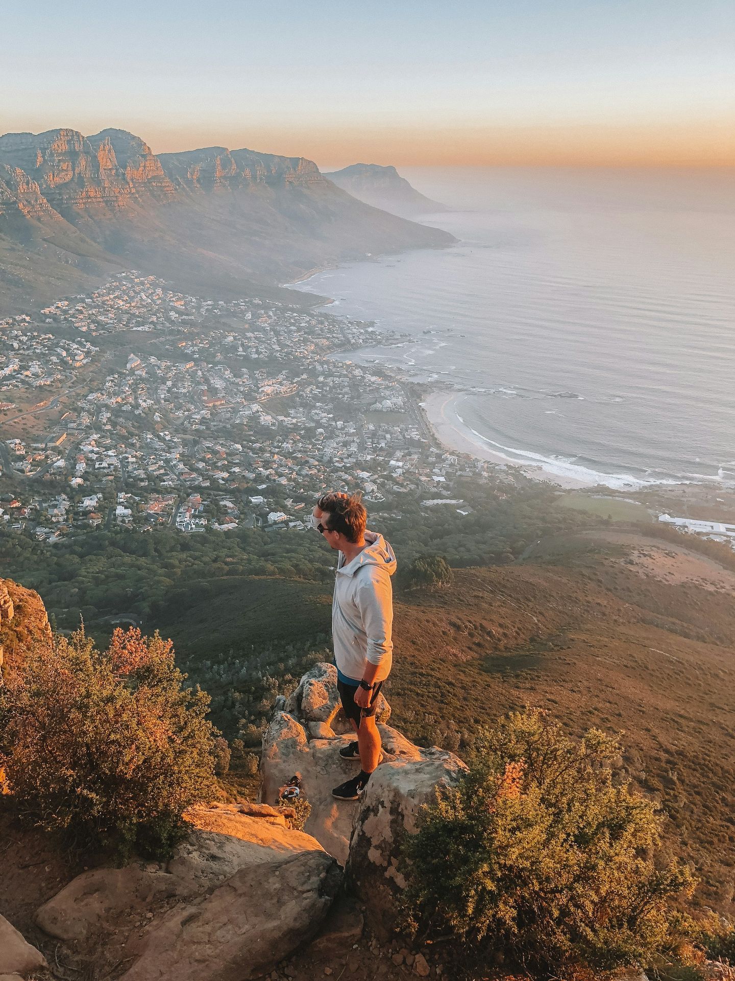 man standing on ledge overlooking town